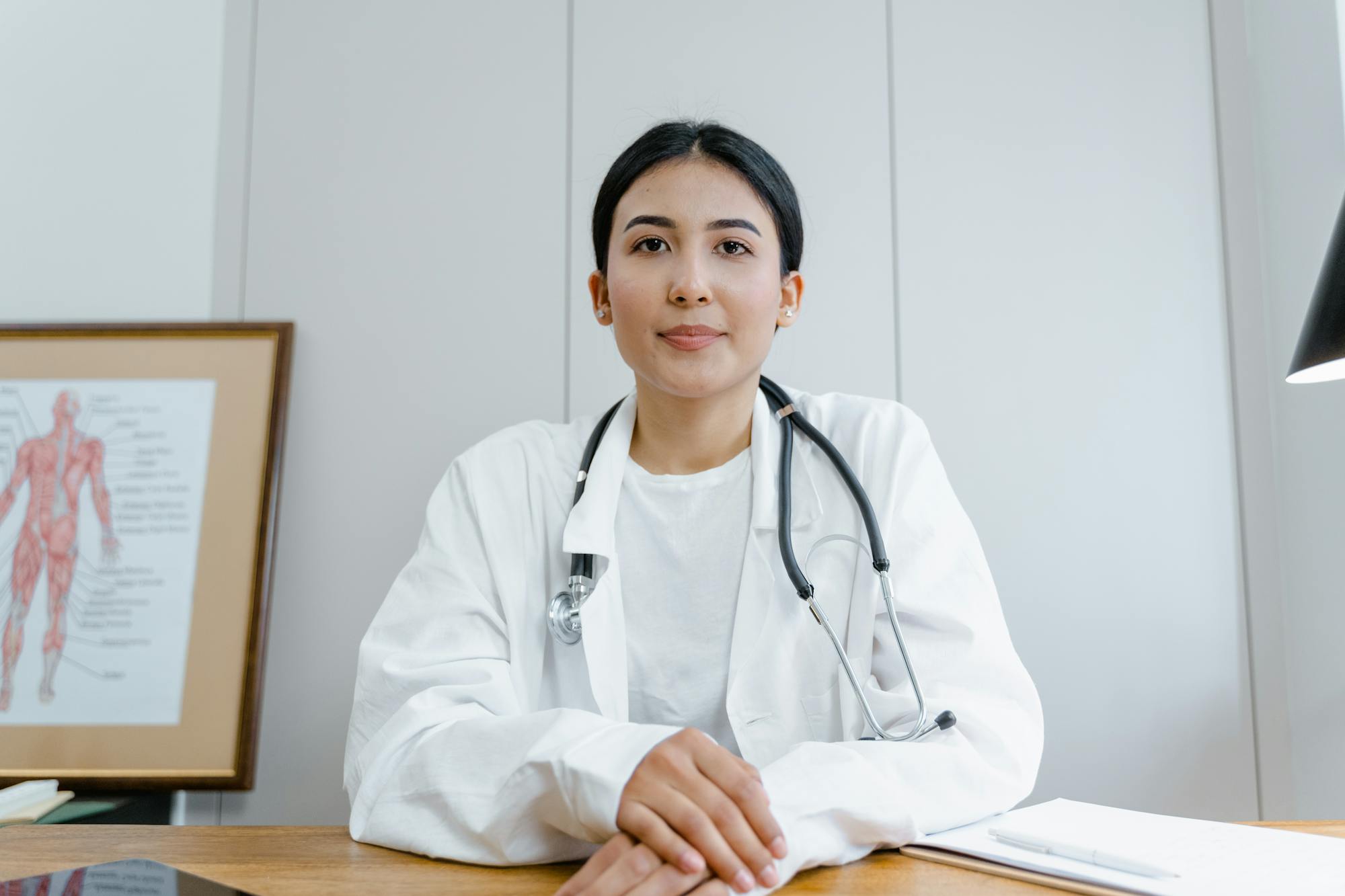 Smiling Caucasian female doctor in white coat — GMC-registered UK doctor